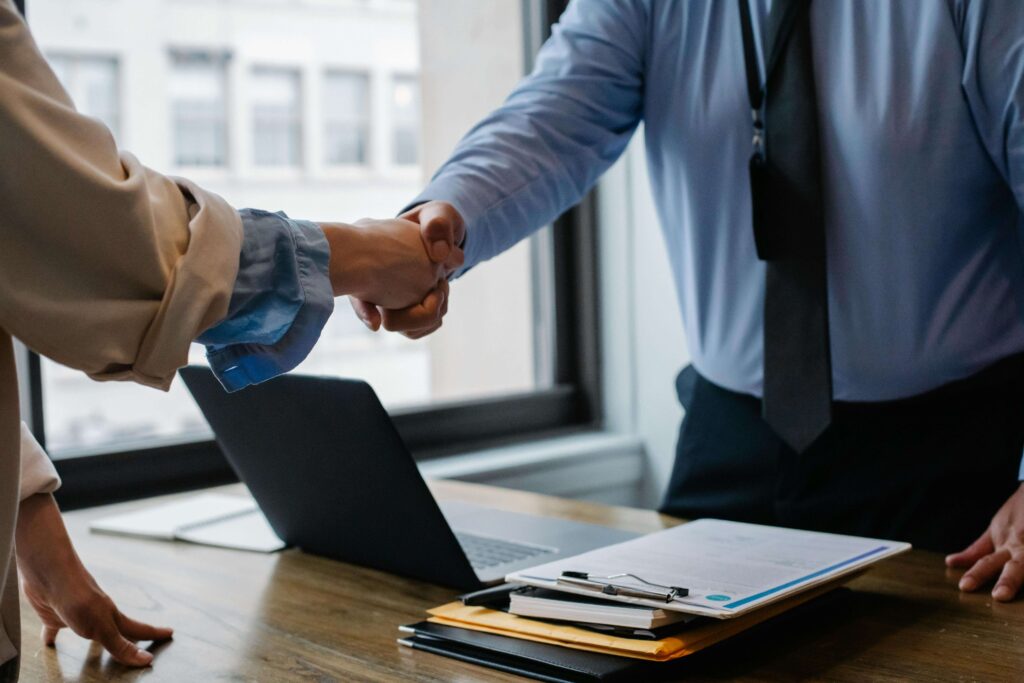 Work with Scout Property Management to Capitalize on Murrieta rental property trends in 2025. Image of two people shaking hands. 